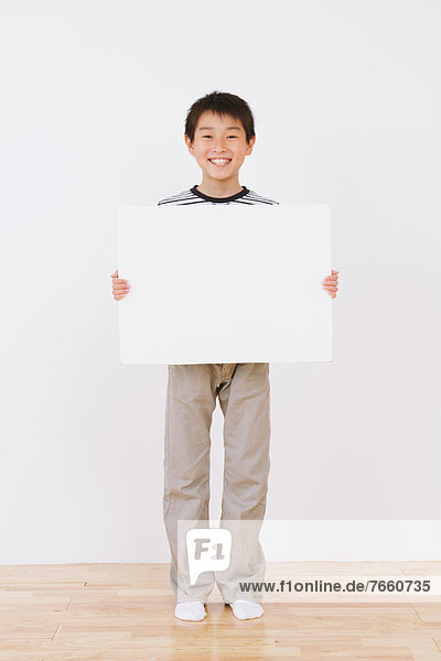 Boy Standing And Holding a White Board