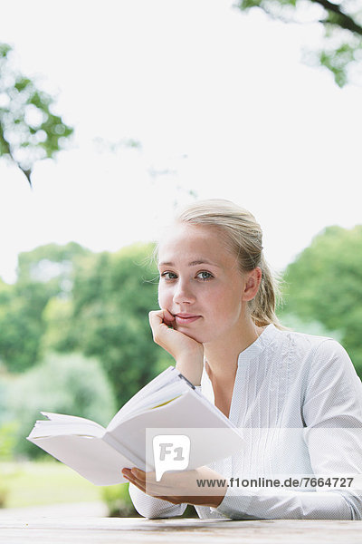Junge Frau beim Lesen im Park