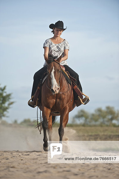 Frau galoppiert auf einem Quarter Horse