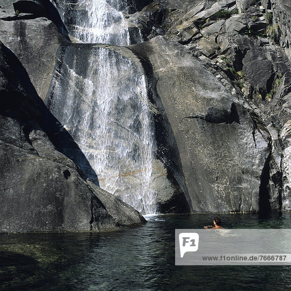 Frau badet an einem Wasserfall Val Verzasca Tessin Schweiz Europa