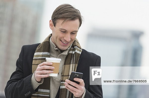 Man in winter clothes looking at phone