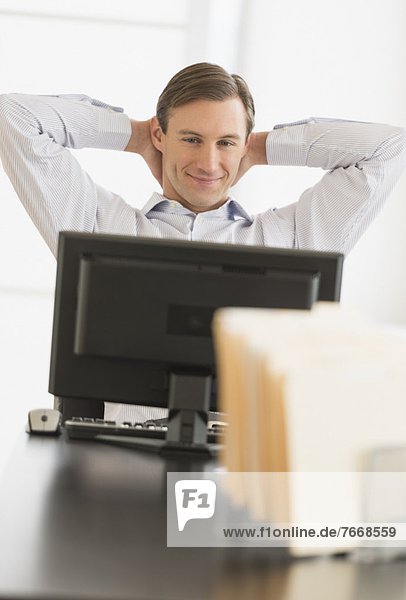 Office worker relaxing in front of computer