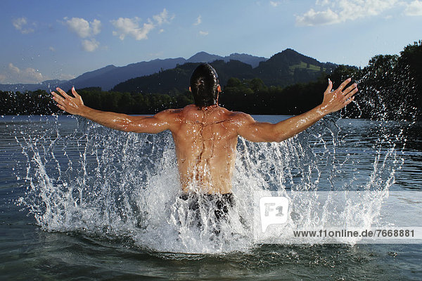 Man splashing about in a lake in Sonthofen  Allgaeu  Bavaria  Germany  Europe