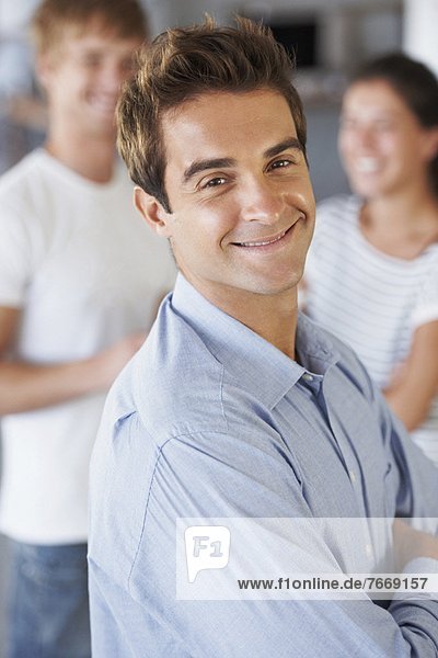 Portrait of man with coworkers in background