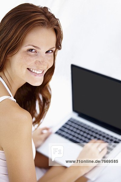 Studio shot of woman using laptop