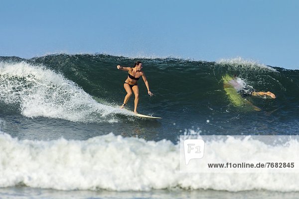 Girl surfer riding wave at popular Playa Guiones surf beach  Nosara  Nicoya Peninsula  Guanacaste Province  Costa Rica  Central America