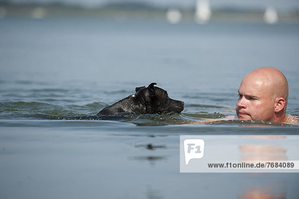Mann Hund See schwimmen