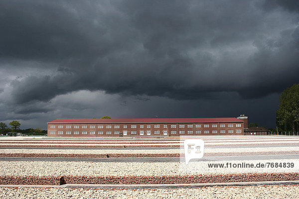 Neuengamme concentration camp memorial site  SS main guard building with guard tower  right  prisoner block 1-4  centre  foundations of the detainee block  emerging thunderstorm