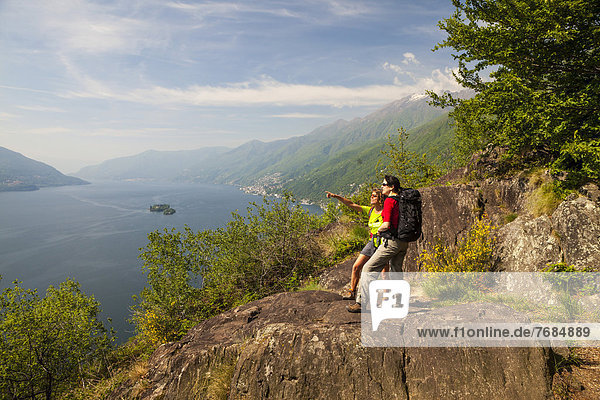 Two women hiking  Balladrum  viewpoint overlooking lake Lago Maggiore  Ticino  Switzerland  Europe