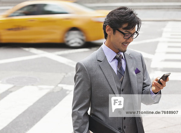 Geschäftsmann mit Handy in der Stadtstraße