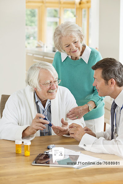 Arzt im Gespräch mit älterer Patientin und Frau