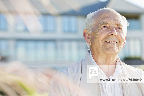 Lächelnder älterer Mann im Freien stehend