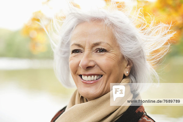 Lächelnde ältere Frau im Park stehend