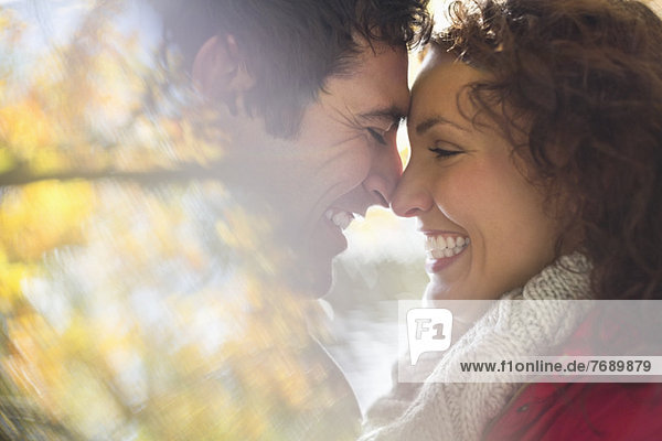 Lächelndes Paar berührt Nasen im Freien