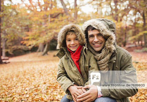 Father and son smiling in park