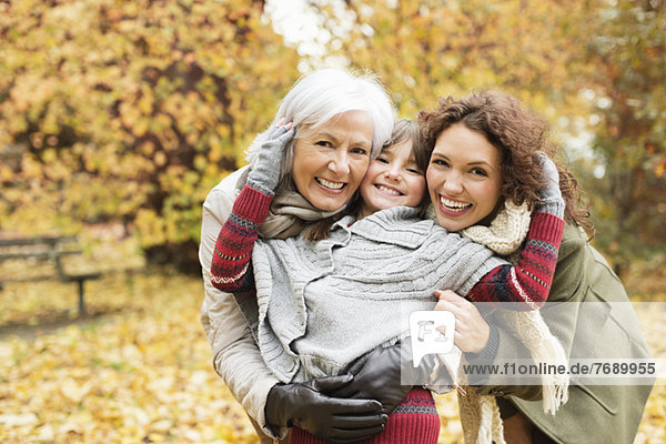 Drei Generationen von Frauen lächeln im Park