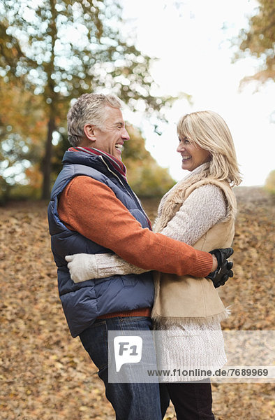 Older couple hugging in park
