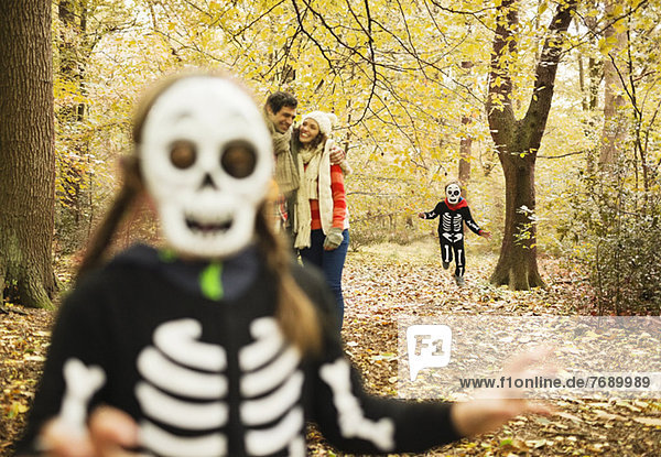 Kinder in Skelettkostümen spielen im Park