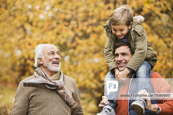 Three generations of men smiling in park