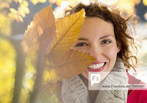 Frau spielt mit Herbstblättern