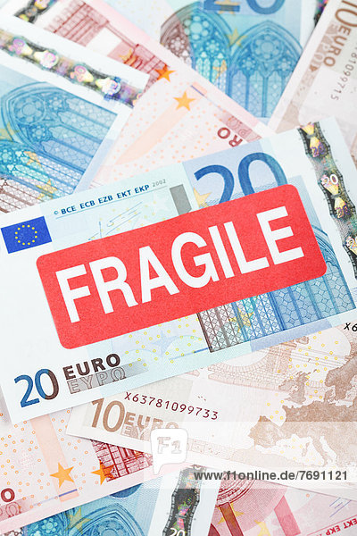 'Euro banknotes with a ''Fragile'' sticker  symbolic image for the eurozone crisis'