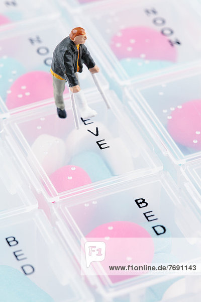 Miniature figurine with broken leg on pill box