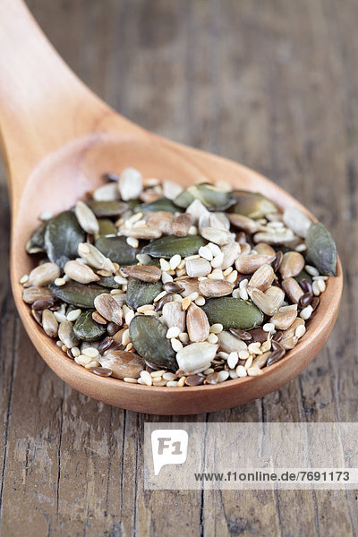 Mixed seeds on wooden spoon