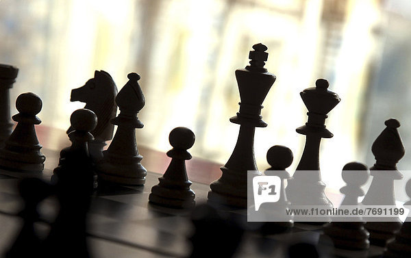 Chess pieces on a chessboard  backlit