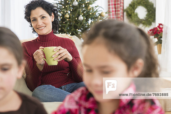 Mother watching daughters in living room