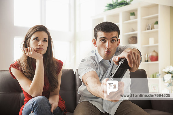 Woman watching boyfriend play video games
