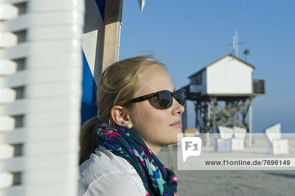 junge Frau junge Frauen Wohnhaus Strand frontal Kleidung Sonnenbrille Stelzenlauf Stelze Stelzen
