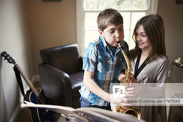Kinder spielen mit Saxophon