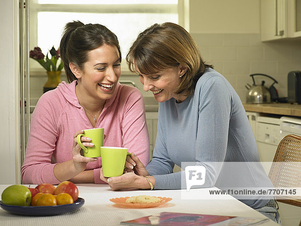 Women having coffee together in kitchen