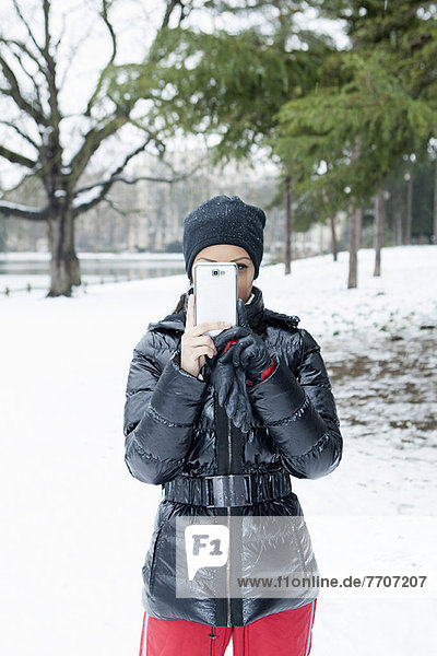 Woman taking picture in snowy field