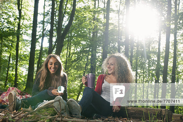 Teenage girls having picnic in forest