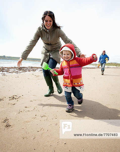 Mutter jagt Tochter am Strand