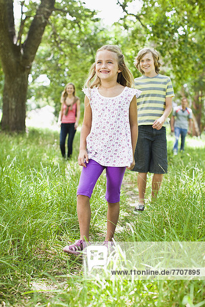 Kinder beim gemeinsamen Spaziergang im Gras
