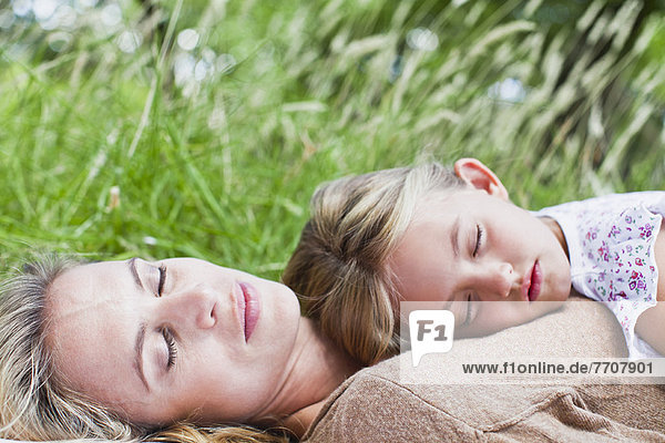 Mutter und Tochter schlafend im Gras