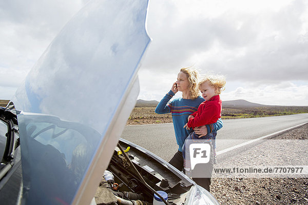 Mother and daughter with broken down car
