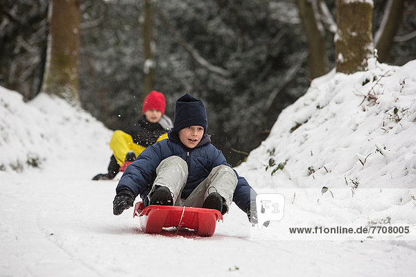 Children sledding on snowy slope