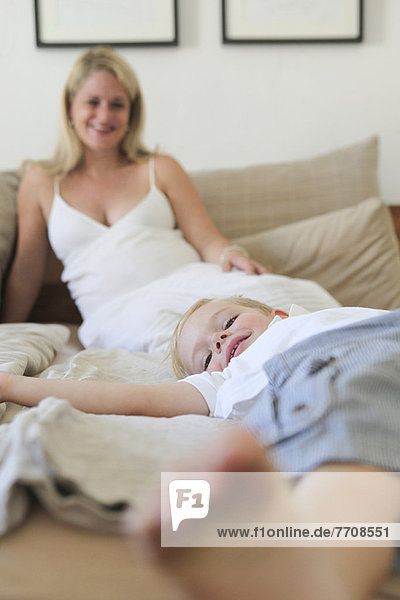 Junge mit Mutter auf dem Bett liegend