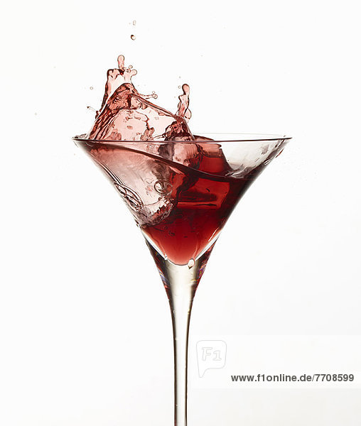 Eiswürfel spritzend im Cocktailglas