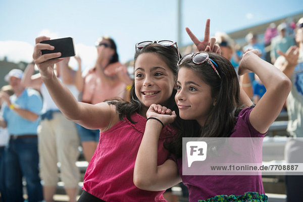 Girls taking a picture of themselves at pop concert