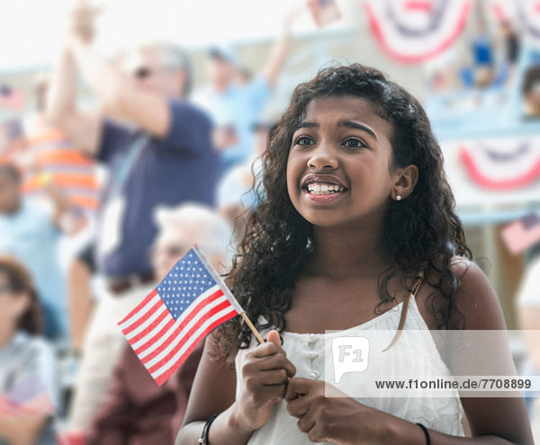 Girl holding american flag  looking anxious