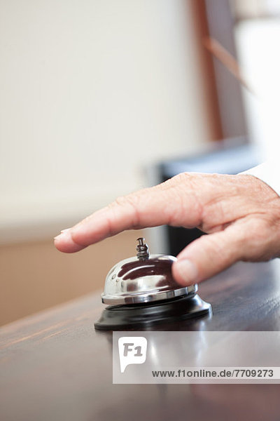 Man ringing bell in hotel lobby