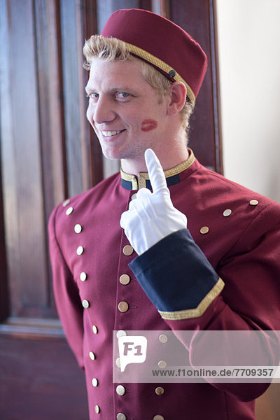 Bellhop smiling with kiss print on cheek