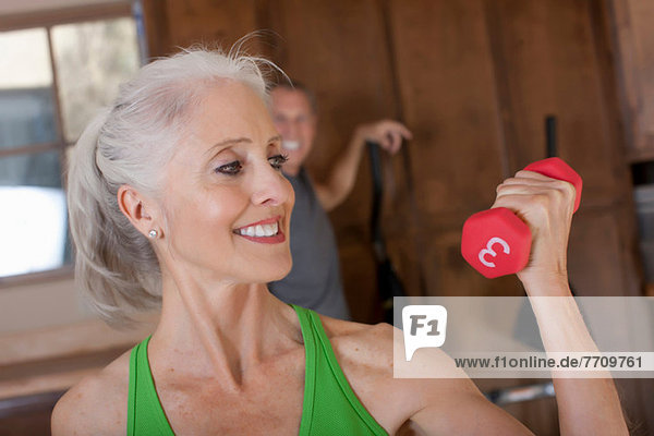 Older woman lifting weights at home