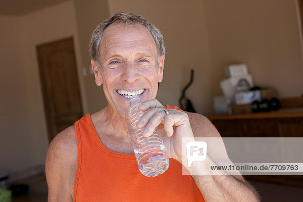 Older man drinking water bottle