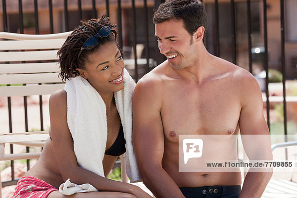 Couple relaxing by swimming pool