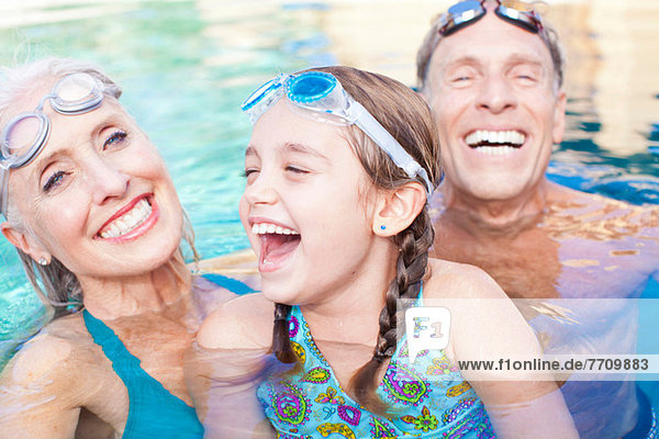 Girl and grandparents swimming in pool